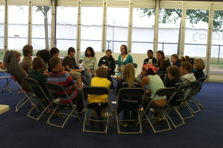 a group of teenagers sitting in a circle having a discussion