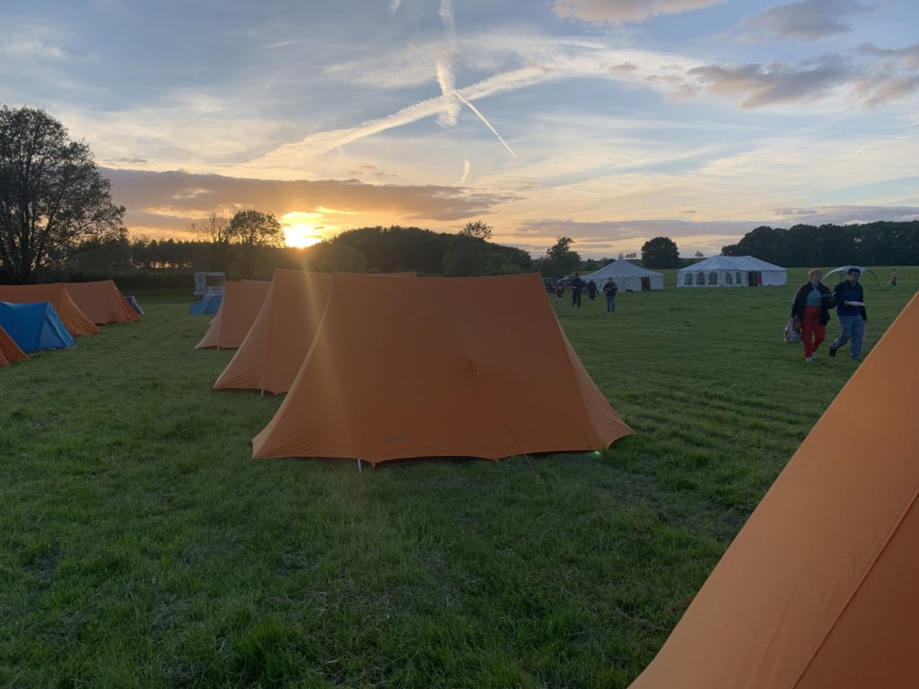 Common Ground camp - image of tents with sunset in the background