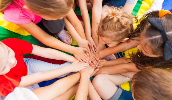 Happy kids members of a large family spending time together. Brothers and sisters making a circle of their hands on a family meeting. Happy family concept