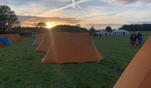 Common Ground camp - image of tents with sunset in the background